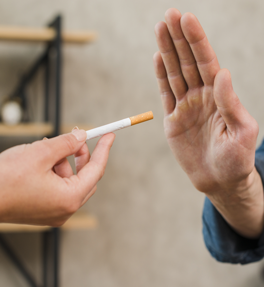 A hand offers a cigarette while another hand gestures a stop sign, indicating refusal.